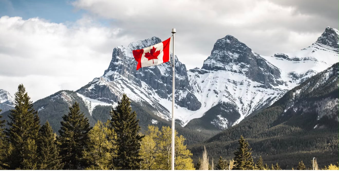 Canadian flag flying before the Rocky Mountains